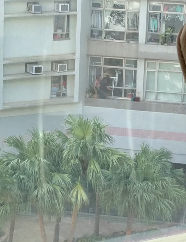 海怡半島一名外傭站出窗外花槽抹窗。(facebook群組「海怡半島討論區」影片)