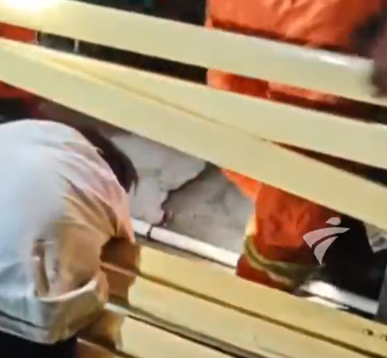 廣東中山港口鎮文化中心一名男子頭部被卡在長椅縫隙中。消防接報後赴現場處置,發現一名30多歲男子頭部卡在長椅木條之間縫隙當中,經現場醫護人員檢查,發現男子神志不清,處於醉酒狀態。(影片截圖)