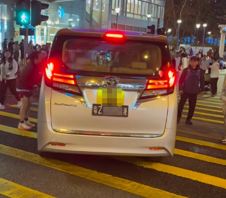 一輛掛有中港車牌的七人車在荃灣楊屋道逆線行駛,在行人綠燈期間無視人群強行橫過斑馬線「U-turn」掉頭,有路人不滿憤而拍打車身。(馬路的事討論區fb影片)