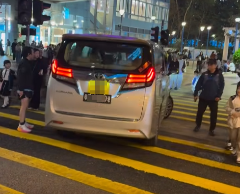 一輛掛有中港車牌的七人車在荃灣楊屋道逆線行駛,在行人綠燈期間無視人群強行橫過斑馬線「U-turn」掉頭,有路人不滿憤而拍打車身。(馬路的事討論區fb影片)