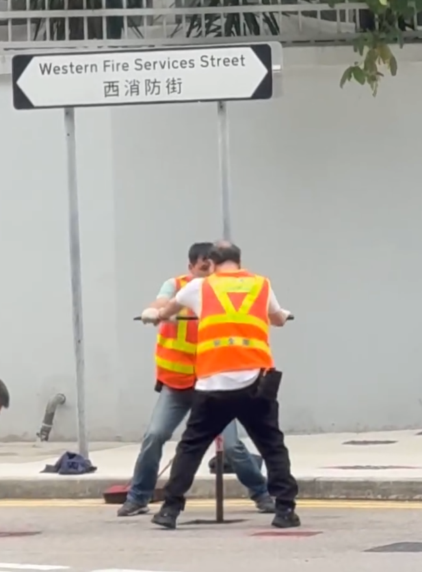 上環西消防街兩名工人在馬路進行維修工作開關水掣,他們面對面、雙手交疊合力轉動閥門的動作極具默契,遠看彷彿是一對正在跳華爾茲舞的拍擋。另外,影片可見附近恰巧有三隻狗路過,成為網民「錯重點」討論對象。(Threads)