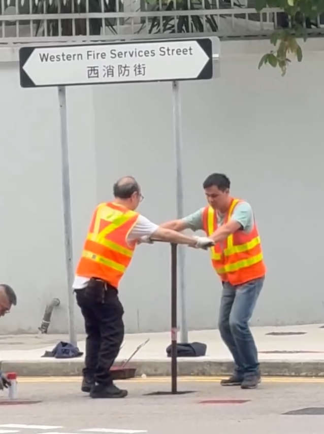 上環西消防街兩名工人在馬路進行維修工作開關水掣,他們面對面、雙手交疊合力轉動閥門的動作極具默契,遠看彷彿是一對正在跳華爾茲舞的拍擋。另外,影片可見附近恰巧有三隻狗路過,成為網民「錯重點」討論對象。(Threads)