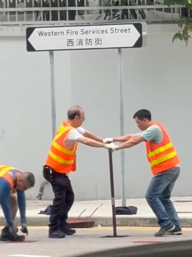 上環西消防街兩名工人在馬路進行維修工作開關水掣,他們面對面、雙手交疊合力轉動閥門的動作極具默契,遠看彷彿是一對正在跳華爾茲舞的拍擋。另外,影片可見附近恰巧有三隻狗路過,成為網民「錯重點」討論對象。(Threads)