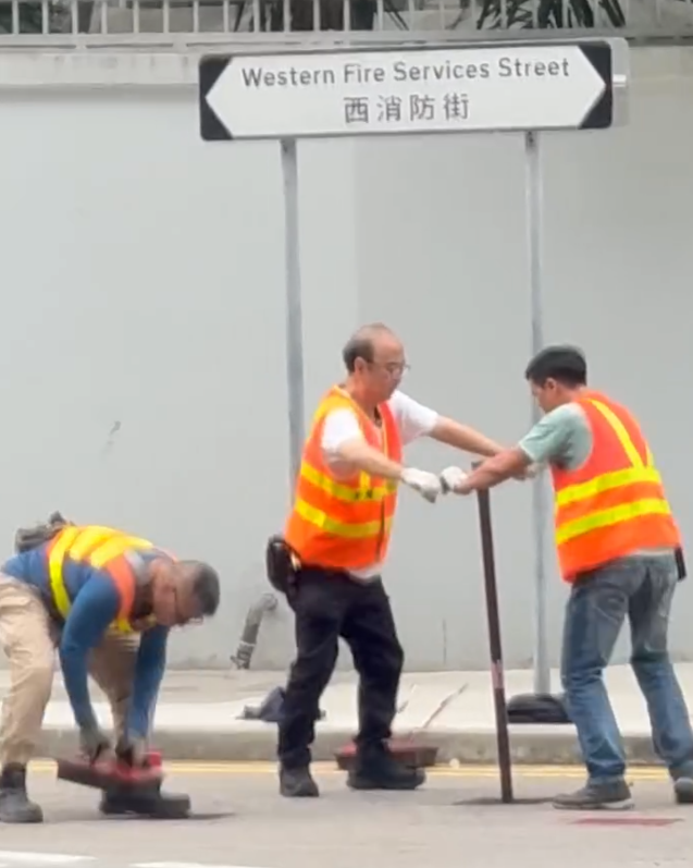 上環西消防街兩名工人在馬路進行維修工作開關水掣,他們面對面、雙手交疊合力轉動閥門的動作極具默契,遠看彷彿是一對正在跳華爾茲舞的拍擋。另外,影片可見附近恰巧有三隻狗路過,成為網民「錯重點」討論對象。(Threads)