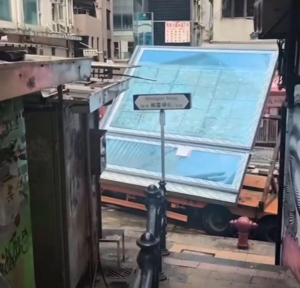 一輛載有玻璃窗等大型建築材料的大型貨車,撞到「威靈頓街」路牌。路牌被撞後傾斜近45度角,最後貨車離開現場,事後引來不少市民及遊客圍觀擺甫士「打卡」拍照。(SH Hong@車cam L(香港群組)FB)