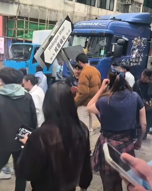 一輛載有玻璃窗等大型建築材料的大型貨車,撞到「威靈頓街」路牌。路牌被撞後傾斜近45度角,最後貨車離開現場,事後引來不少市民及遊客圍觀擺甫士「打卡」拍照。(SH Hong@車cam L(香港群組)FB)