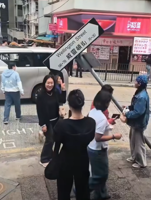一輛載有玻璃窗等大型建築材料的大型貨車,撞到「威靈頓街」路牌。路牌被撞後傾斜近45度角,最後貨車離開現場,事後引來不少市民及遊客圍觀擺甫士「打卡」拍照。(SH Hong@車cam L(香港群組)FB)