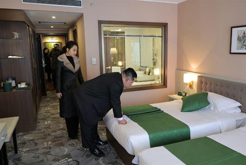 金正恩在房間用雙手握拳按壓床墊,親自檢測床的軟硬度。(勞動日報)