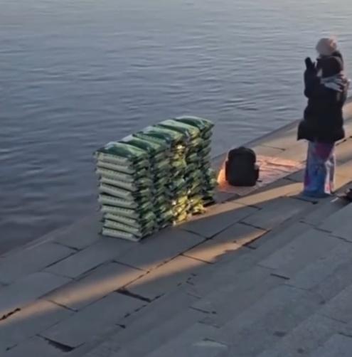 有民眾帶著多袋白米到江邊,在現場跪拜後,把白米倒入江裡。(微博)