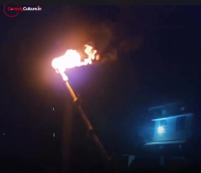 男子手持一根一端正在燃燒的木棍,並將火焰朝向太陽能板照射。(IG)