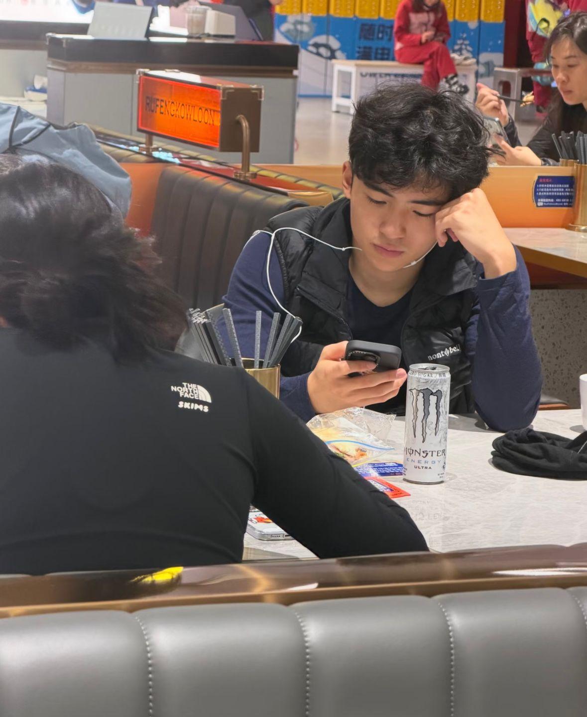 Lucas現身深圳某餐廳時,期間他戴上耳機一邊在吃東西,一邊在玩手機