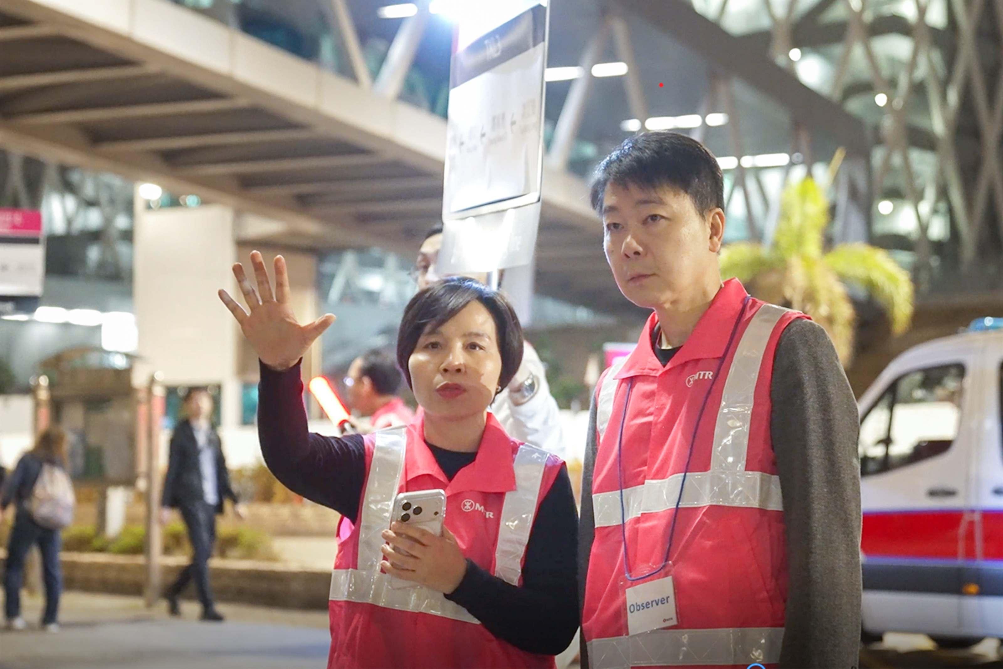 港鐵舉行大型聯合演習,港鐵代表 向將軍澳區「社區聯合應變組」及相關政府部門代表介紹調景嶺站港鐵免費接駁巴士的新安排,港鐵公司副總監—車務營運及本地鐵路李婉玲(圖 二左)在場視察新安排的運作。