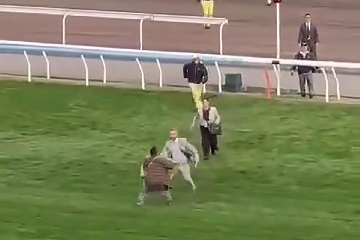 有人在賽馬期間闖入賽道,隨即被工作人員制服,賽事未受影響。(網上影片截圖)