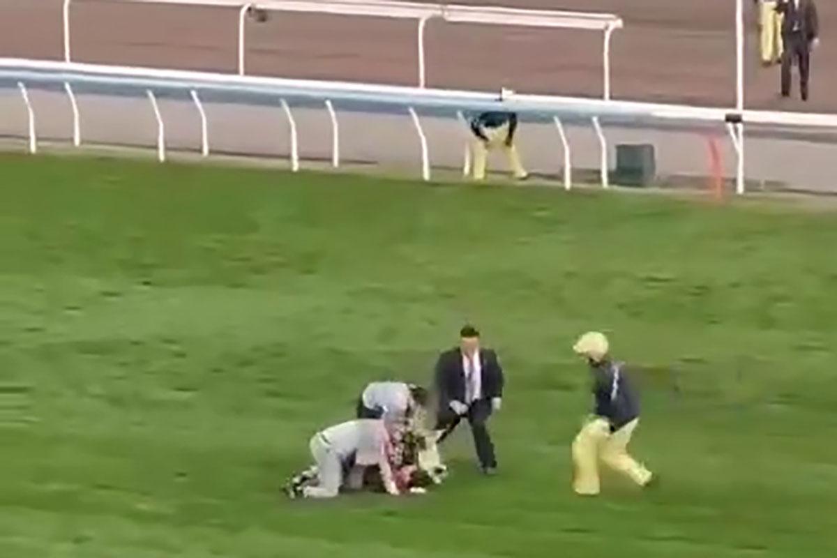 有人在賽馬期間闖入賽道,隨即被工作人員制服,賽事未受影響。(網上影片截圖)