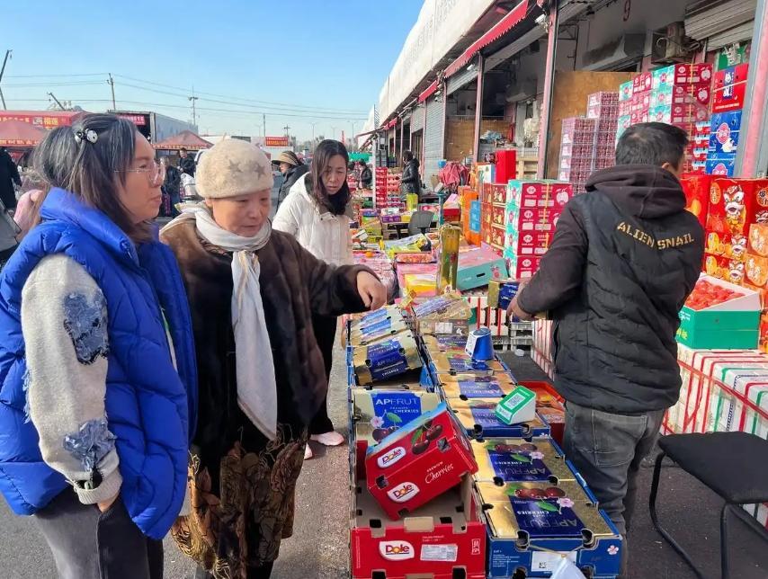 批發市場上精品水果交易區櫻桃因降價而銷售火爆。(《北京日報》)
