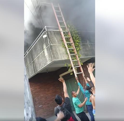 民眾試著舉起梯子讓女子爬下,但梯子不夠長。(互聯網)