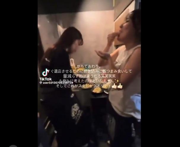 一名店員拿餐碟上的食物,另一人把食物塞進嘴裡吃。(互聯網)