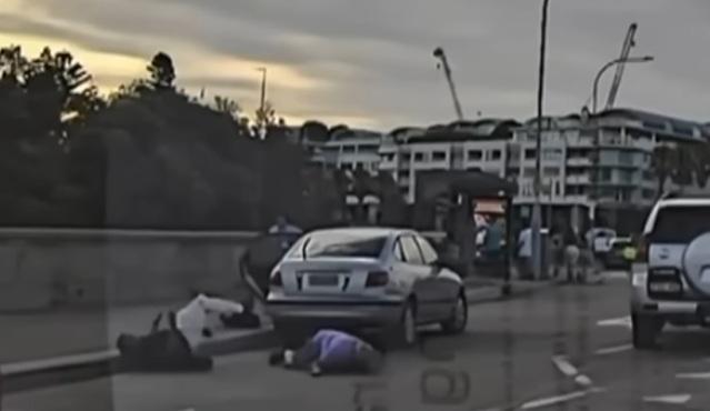 車cam片段可見,穿紫色上衣的古爾曼將槍手推倒,自己也跌倒。(互聯網)