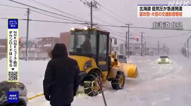 北海道北見市厚厚積雪,有私家車拋錨,由剷車拖走。(互聯網)