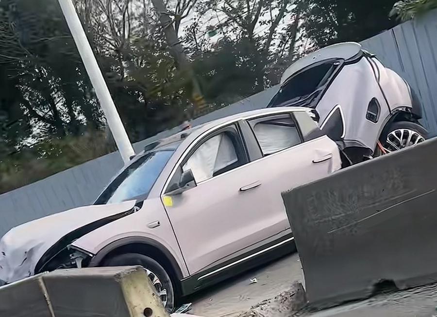 一輛紫色蔚來電動車撞上水泥墩後,車尾斷開。(新民晚報)