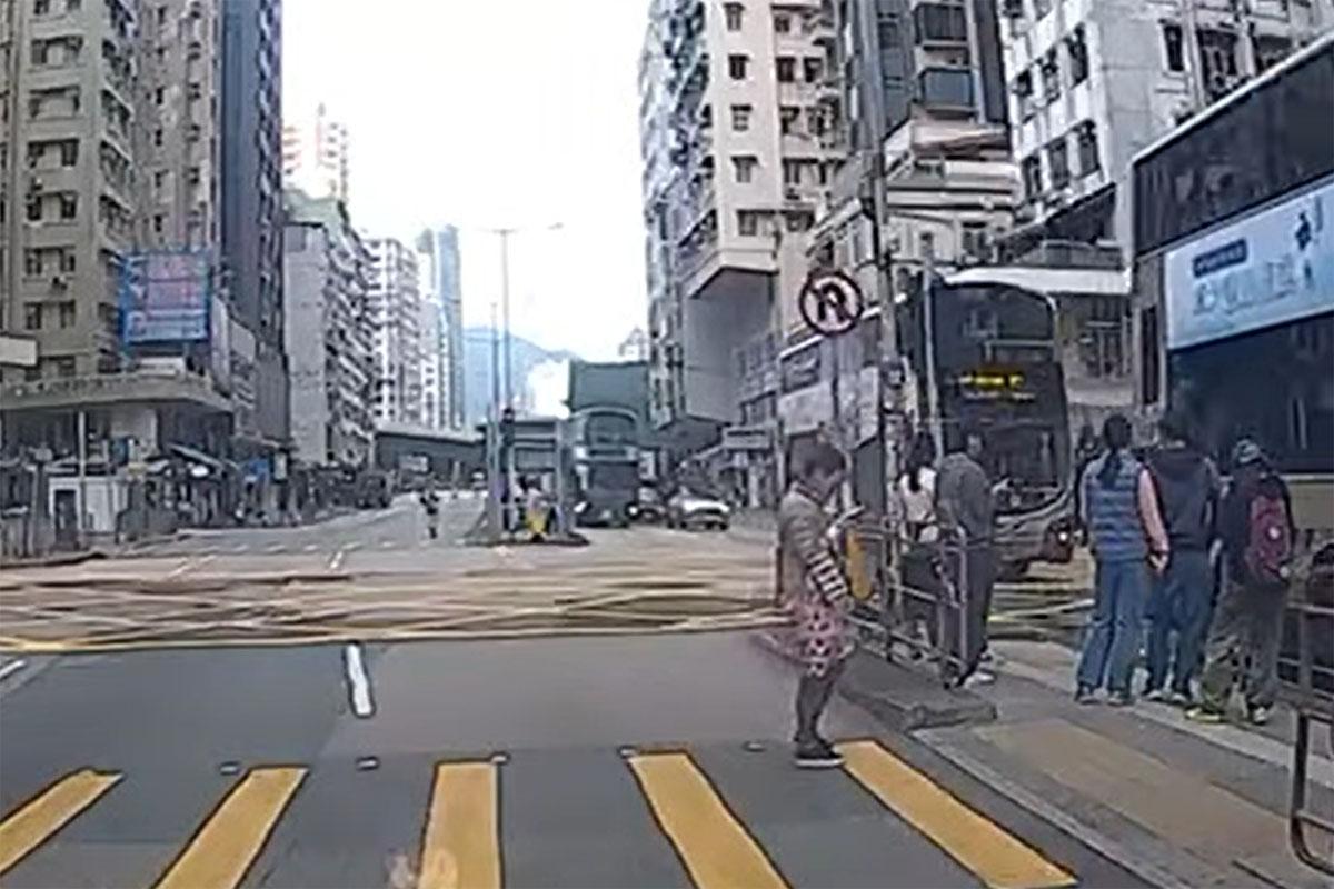 事發時女途人突從安全島衝出,被駛至的九巴撞倒及捲入車底。(網上影片截圖)