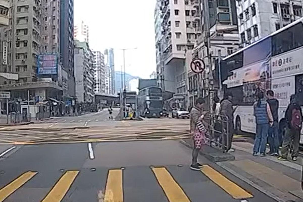 事發時女途人突從安全島衝出,被駛至的九巴撞倒及捲入車底。(網上影片截圖)
