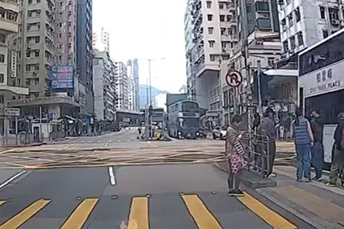 事發時女途人突從安全島衝出,被駛至的九巴撞倒及捲入車底。(網上影片截圖)