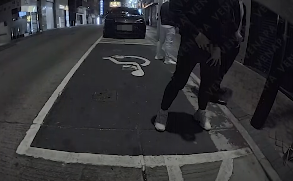 其中2人突然在1輛Tesla車尾後方位置,拉下褲鏈當街小便。(FB@車cam L(香港群組))