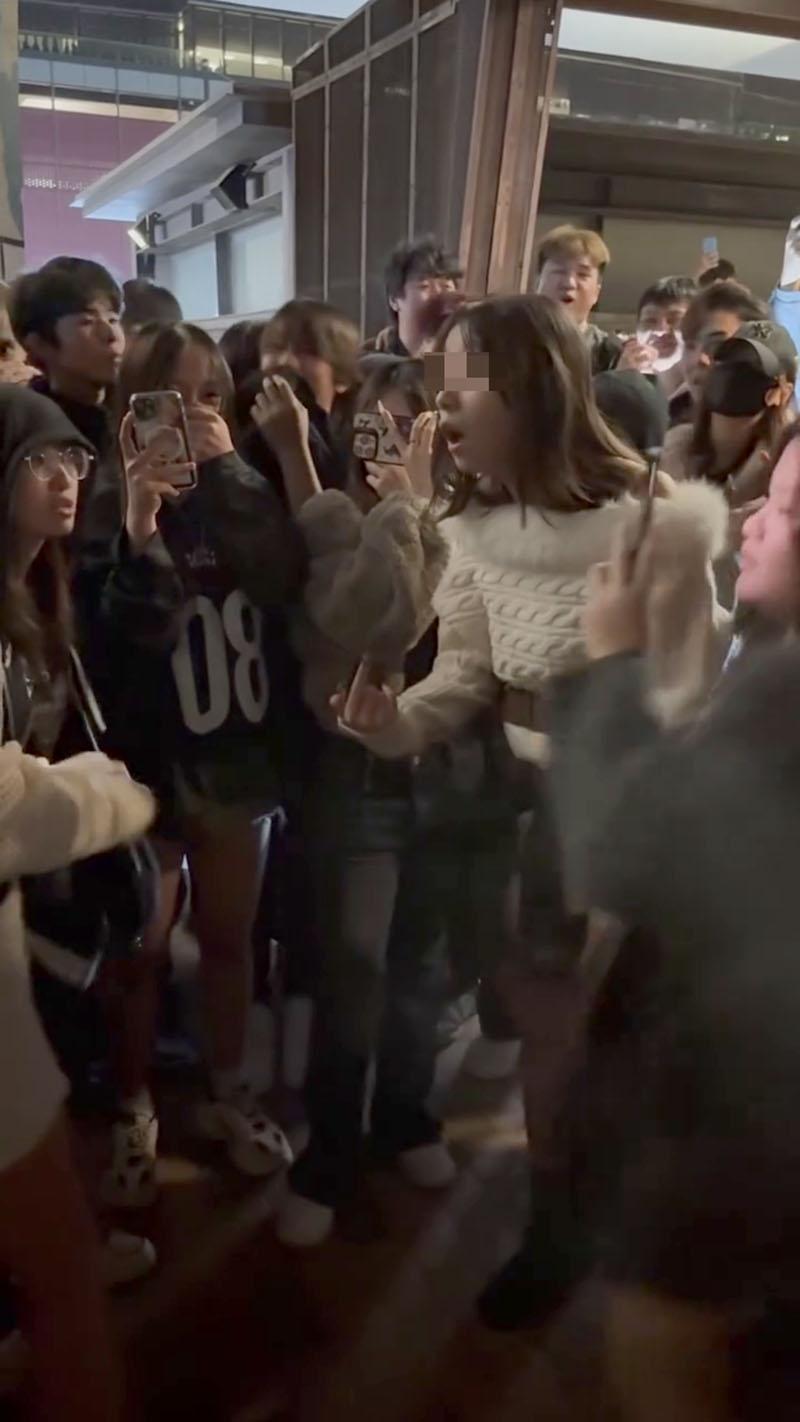 觀塘海濱公園元旦日有大批年輕人聚集,圍觀一名少女懷疑暴力欺凌另一少女並起哄。(網上影片截圖)