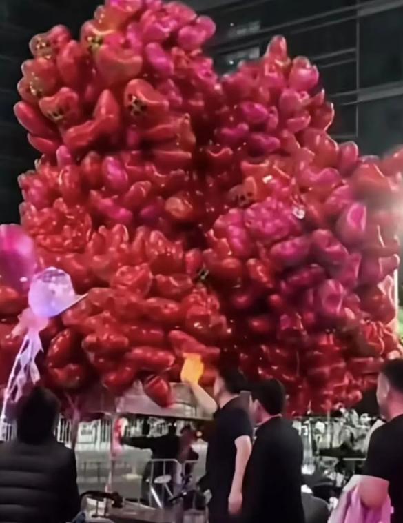 一名男子路過販售氣球攤販時突然將氣球點燃。(極目新聞)