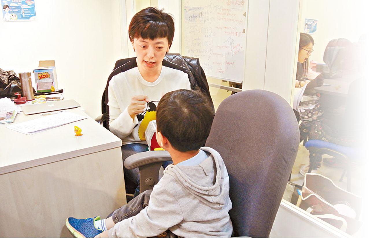 秦蓁為幼兒進行言語能力評估。