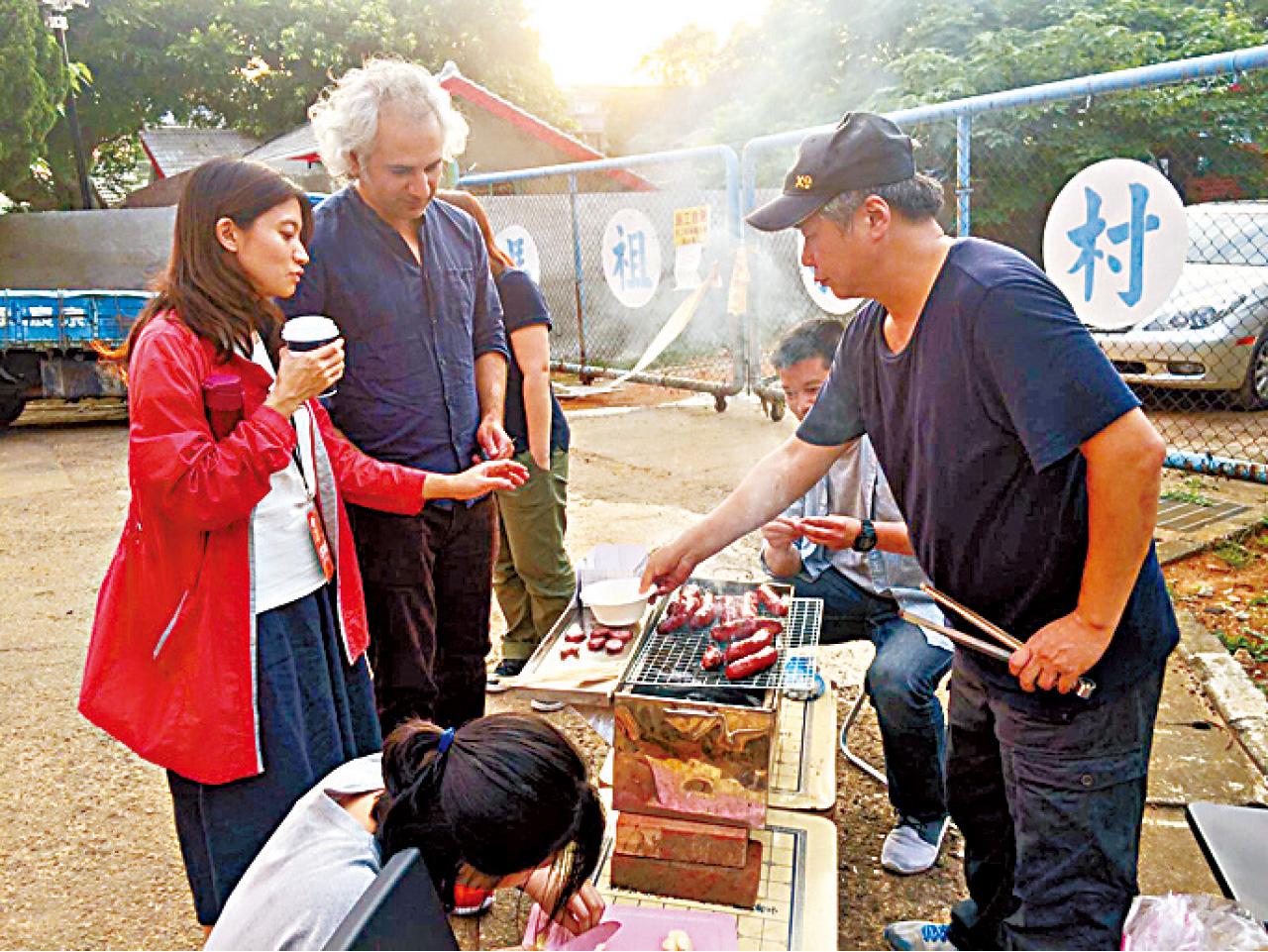 策展人之一吳乙峰(右)親自到戶外放映場地烤台式香腸給觀眾。