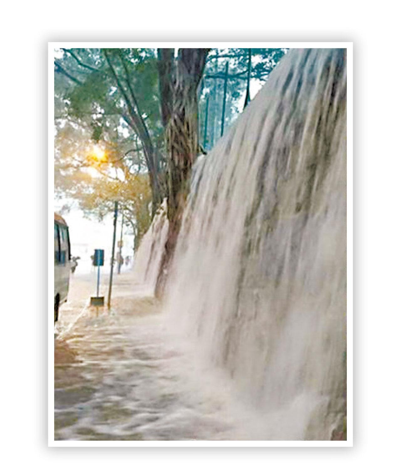 雨水沿西環科士街一幅石牆瀉下。(FB香港突發事故報料區)