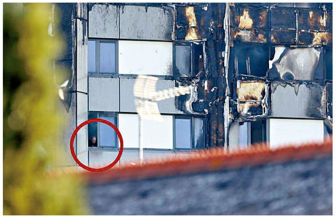 一名居民(紅圈)伸出窗外求救。