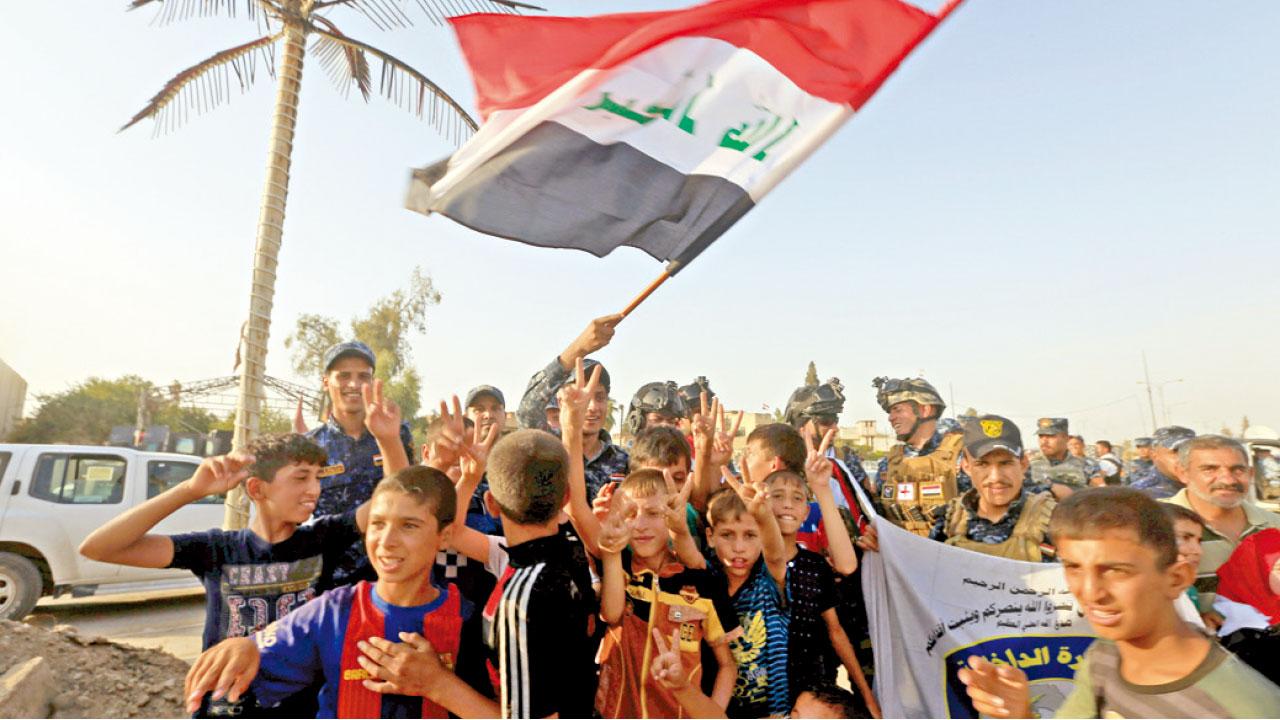 大批民眾在摩蘇爾西部上街揮動國旗慶祝光復。(路透社、美聯社)