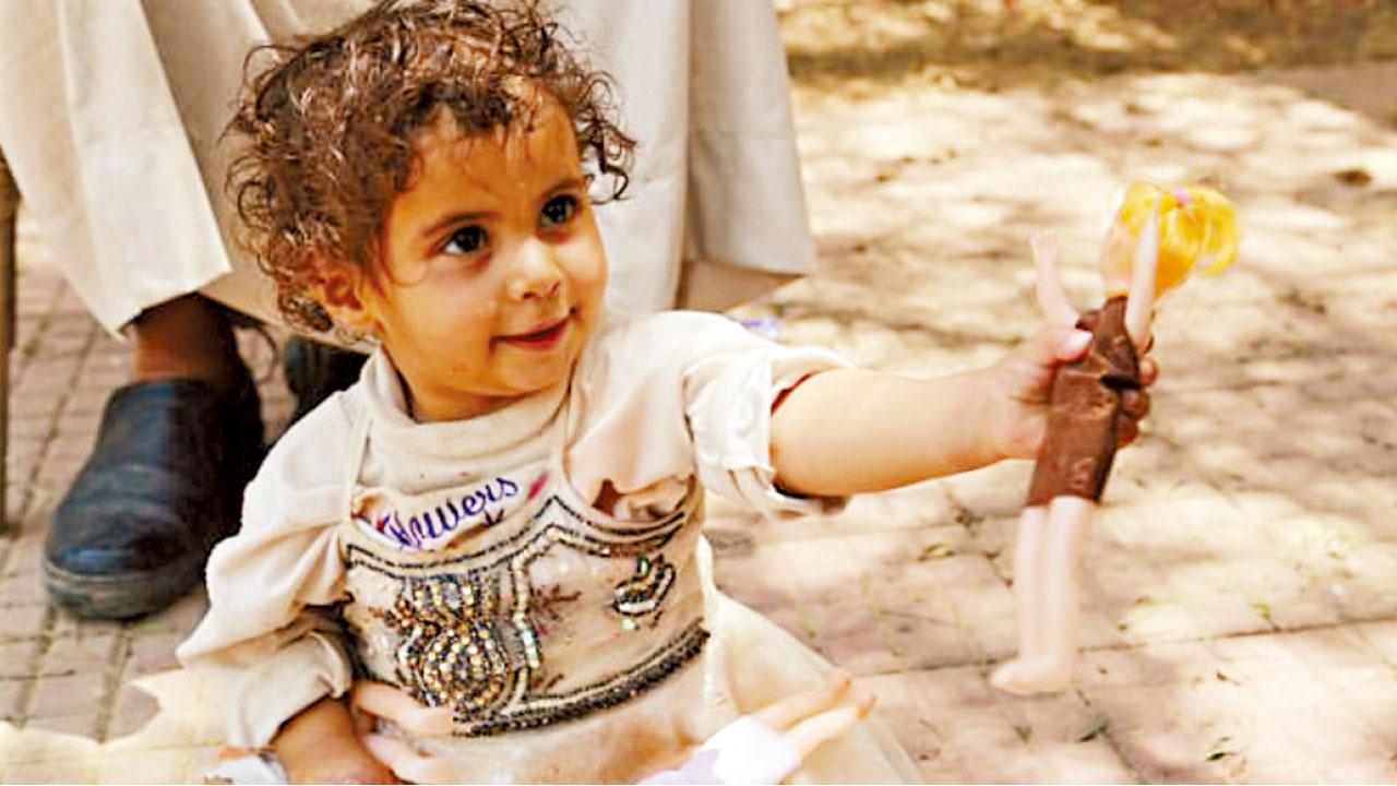 扎胡爾拿著心愛的洋娃娃。(互聯網)