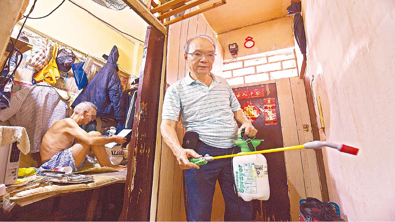 鄧渭然(右)為堅哥(左)的家噴灑環保滅蟲蝨劑。