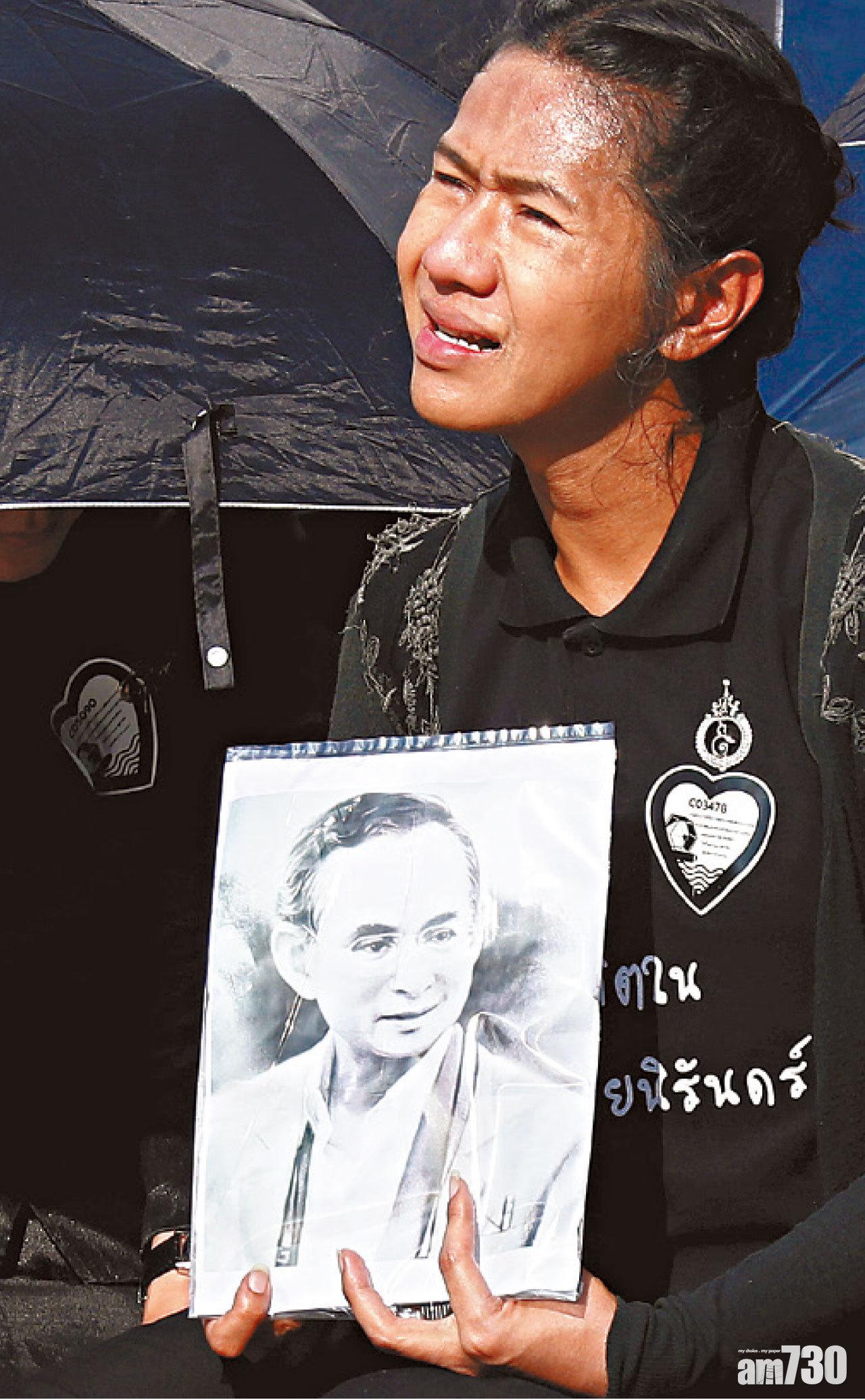 民眾手持普密蓬遺像,傷心送別這位一代泰王。