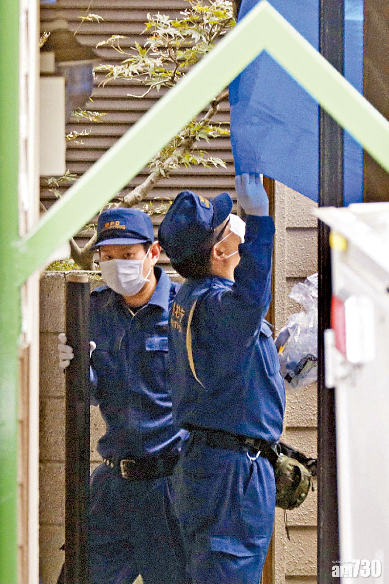 警員在案發單位外蓋上藍布。