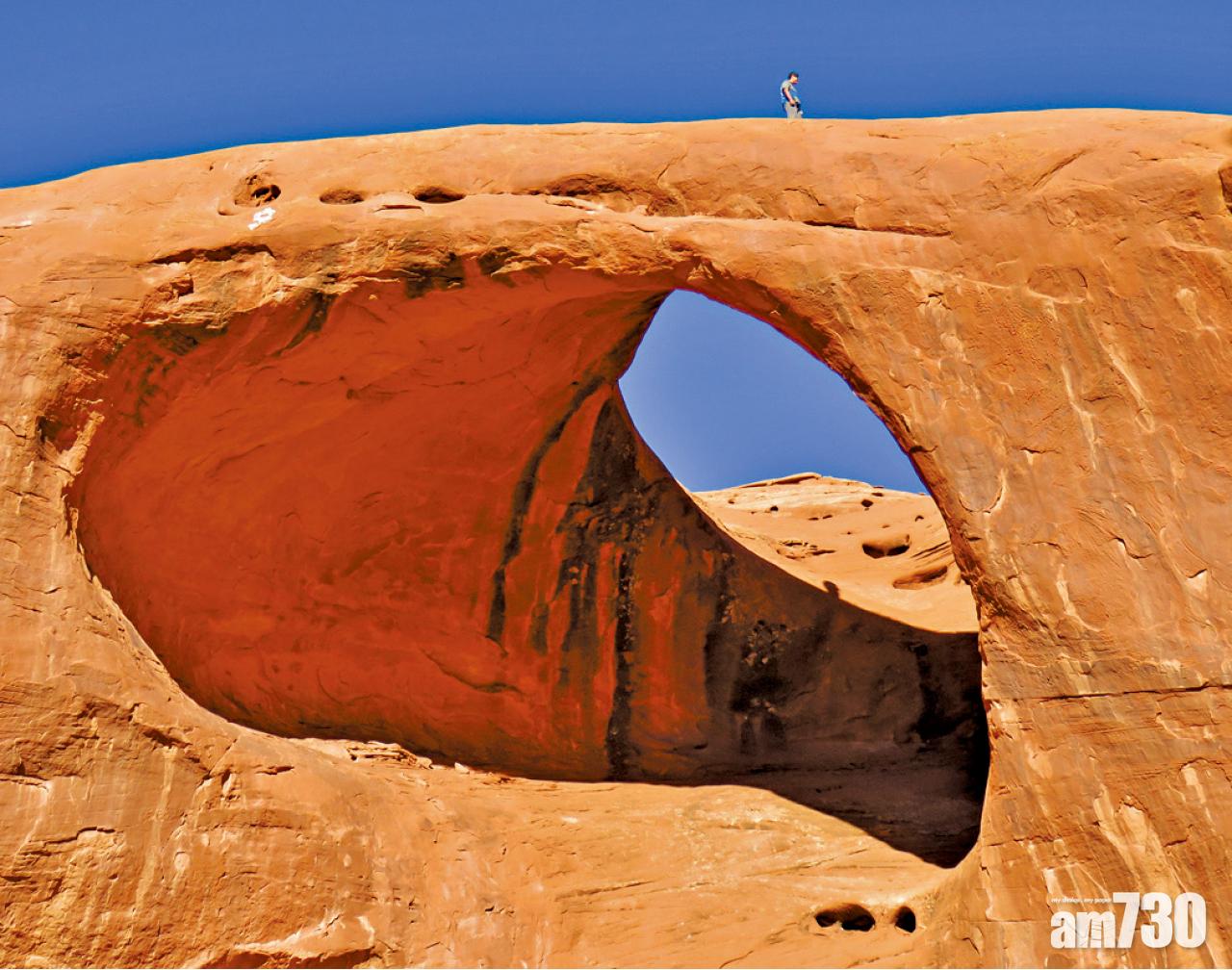 不畏高遊客攀上紀念碑谷Moccasin Arch岩拱。