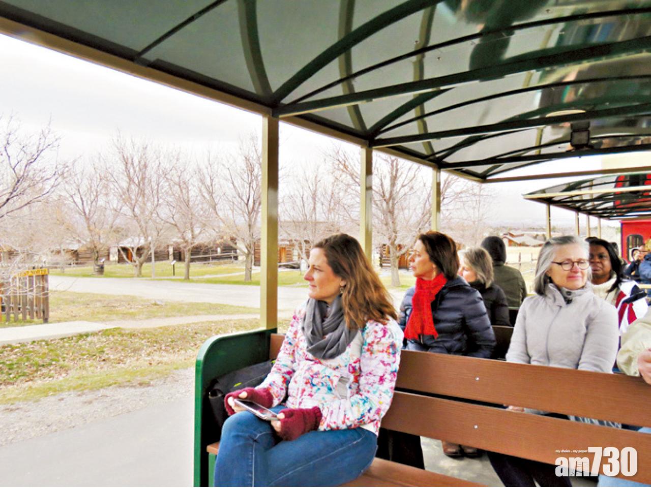 遊人坐小火車遊古村。