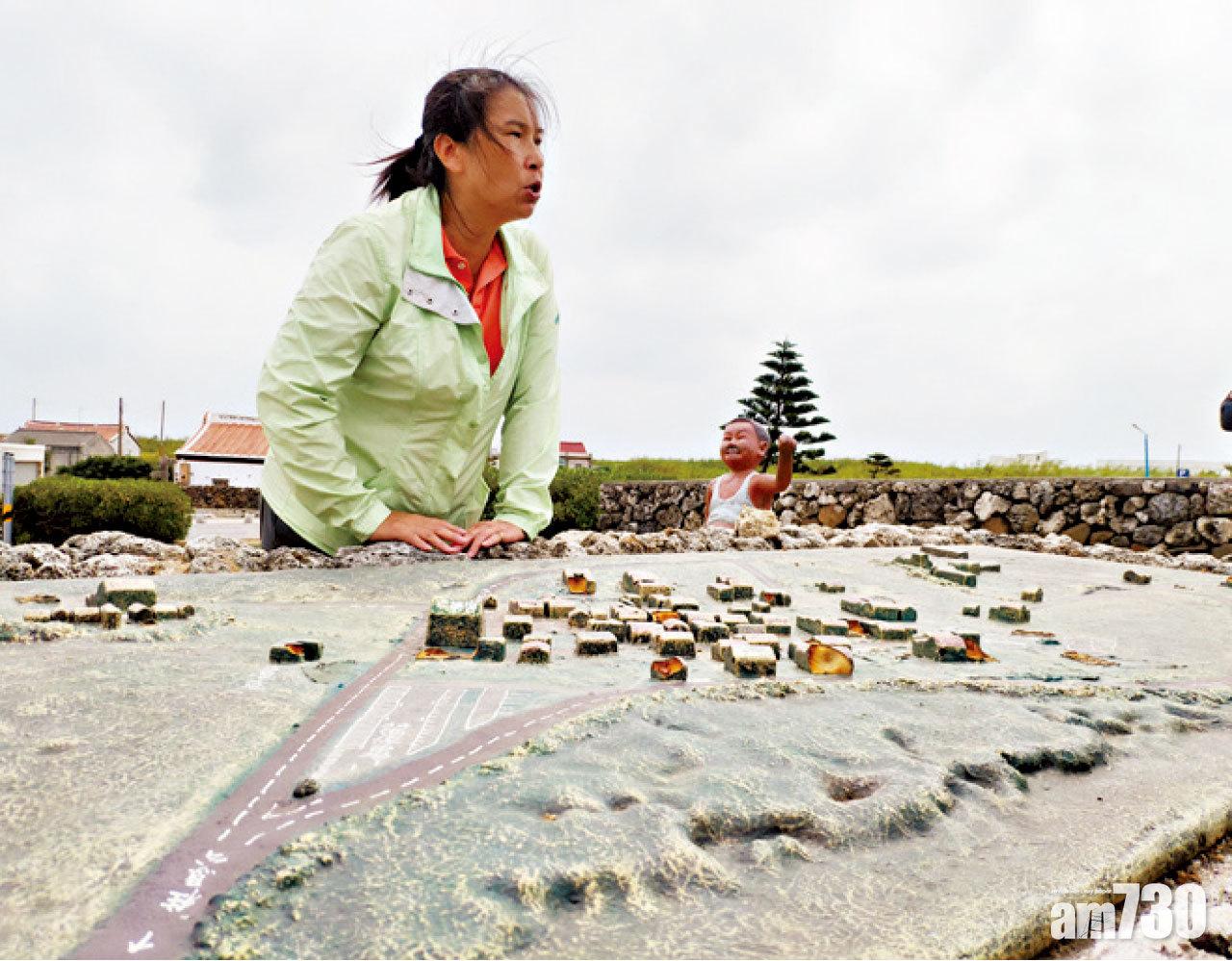 導遊正利用村口的模型講解二嵌村的概況。