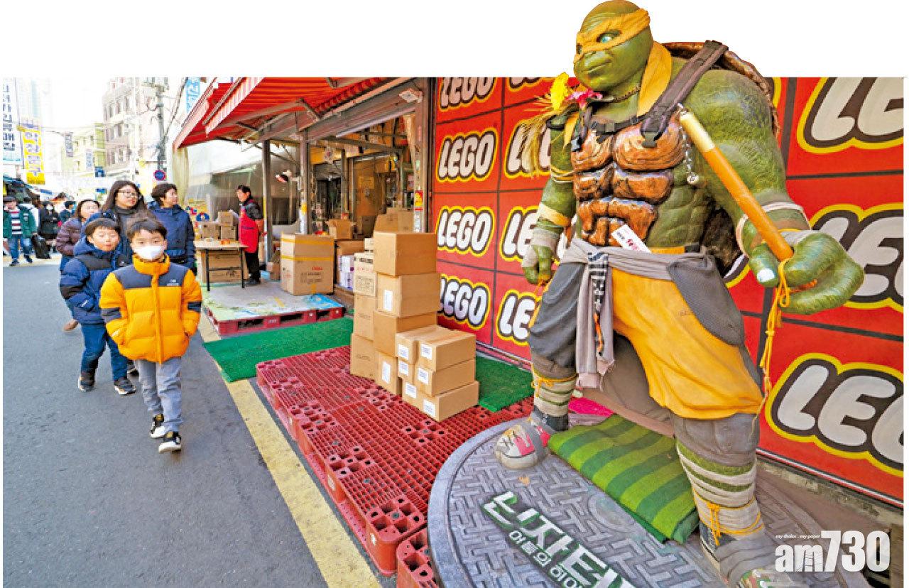 很多玩具店都以巨型動漫人偶作招徠,這小朋友也太淡定吧。