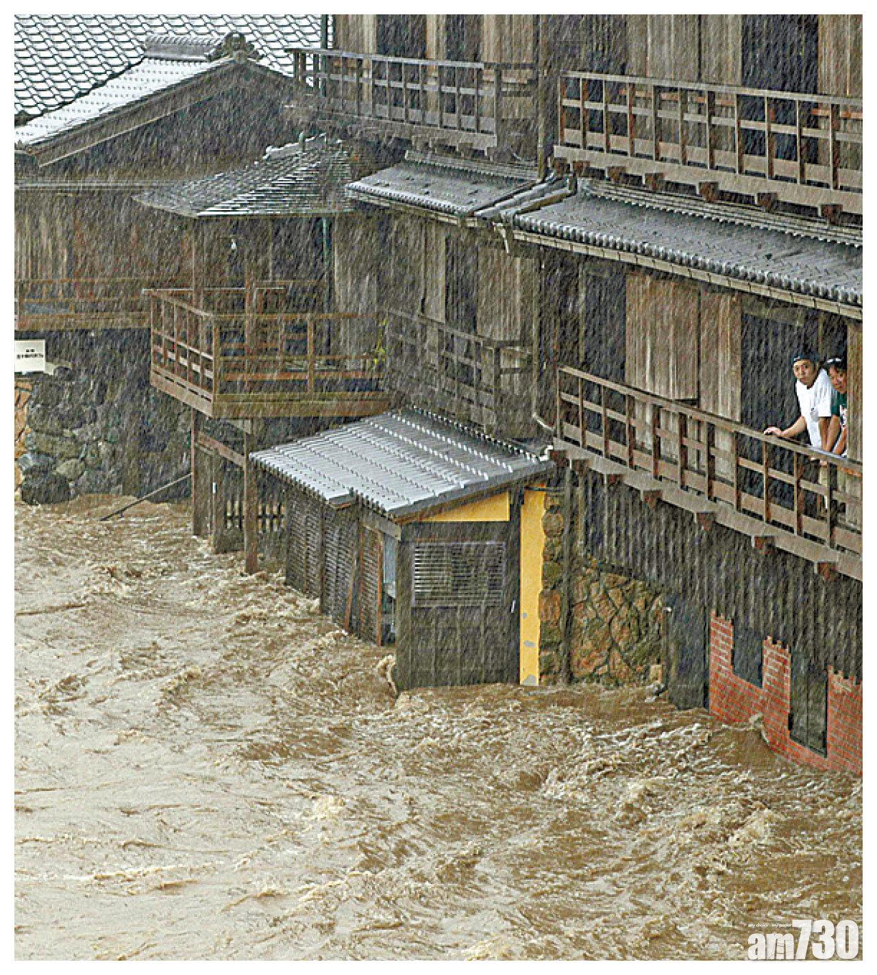 3.洪水幾乎淹沒地下樓層,居民站樓上觀看。