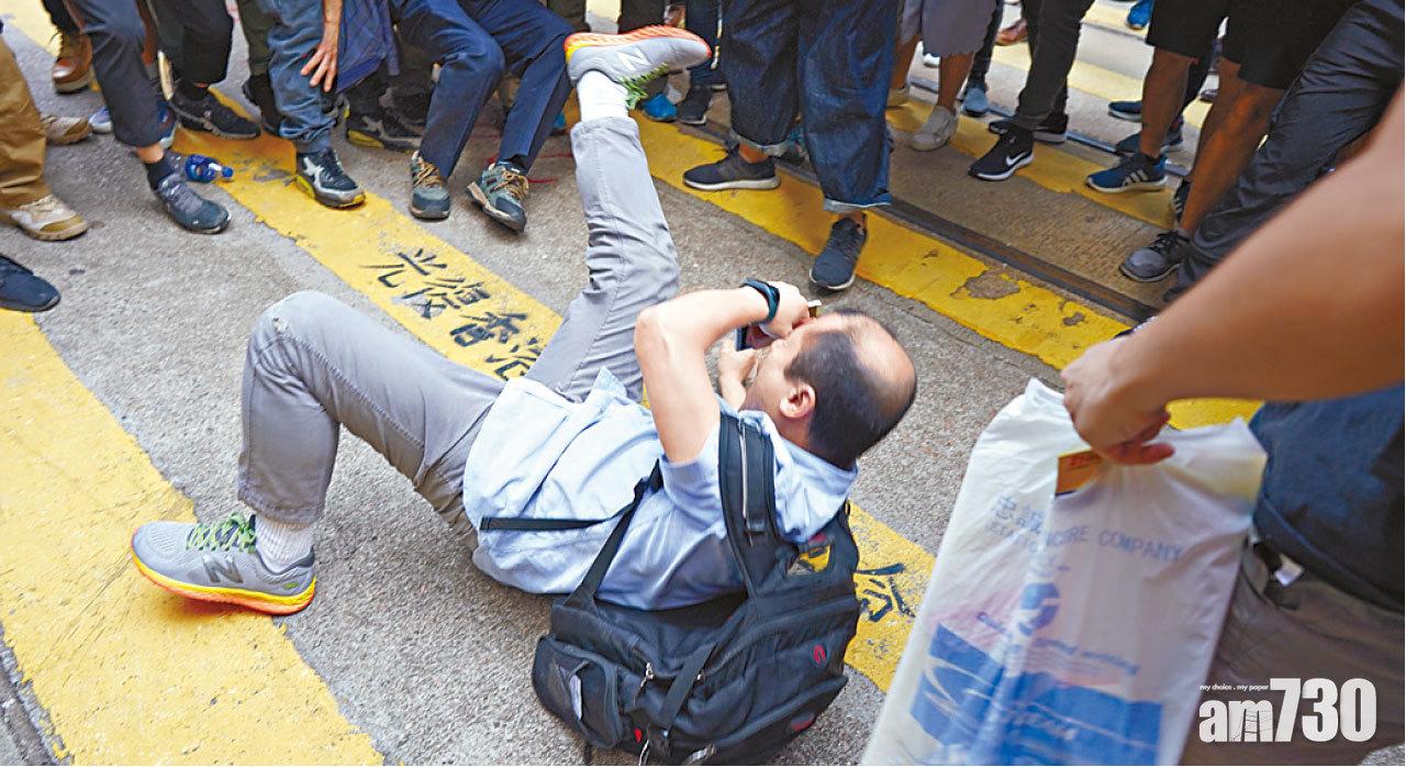 中年男疑襲擊記者後被「私了」倒地。(陳奕釗攝)