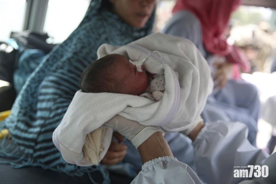 一名嬰兒在襲擊後被送上救護車。(美聯社)