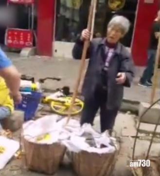 城管人員帶老婦到市場擺檔。(互聯網)