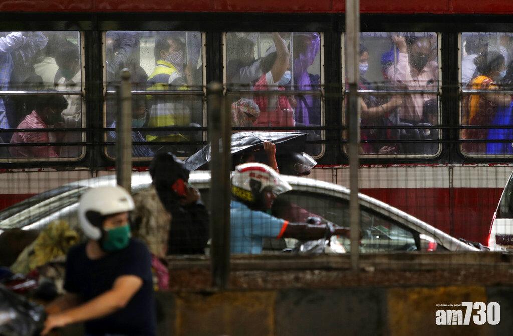 孟買民眾乘公共交通時紛戴口罩防疫。(美聯社)