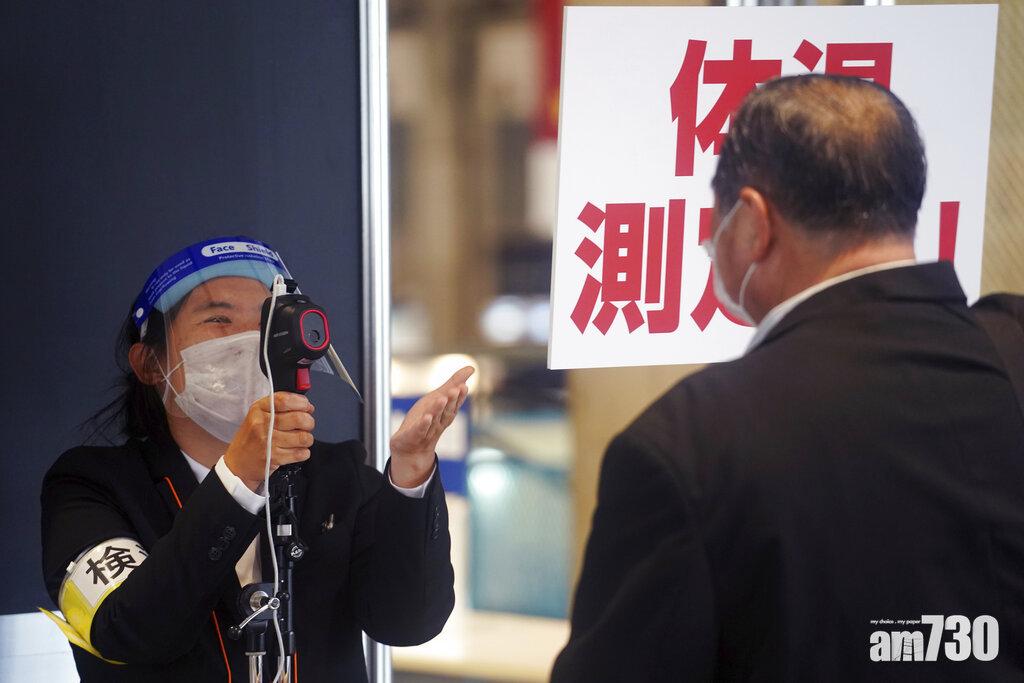 千葉縣民眾入展覽場地前須量體溫。(美聯社)