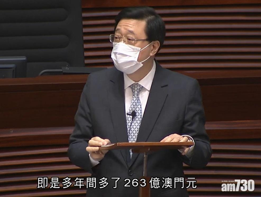 李家超在立法會回應有關港人申請「良民證」的質詢。(電視截圖)